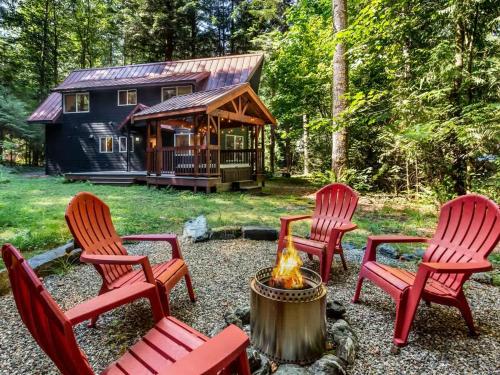 un gruppo di sedie rosse e un braciere davanti a una baita di Wild Goose Lodge a Glacier