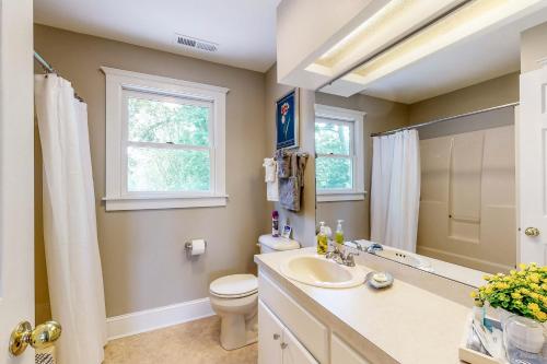 a bathroom with a sink and a toilet and a window at Salisbury Waterfront: Schumaker Pond Paradise! in Salisbury