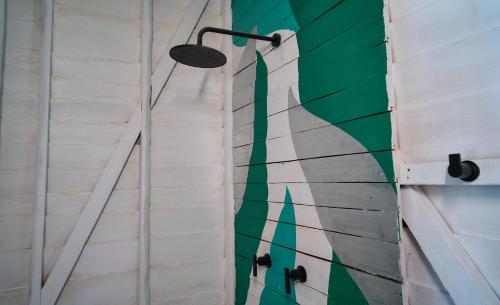 a wall with a painting of a surfboard on it at El Faro Beach Front by ÓOL Hotels in Holbox Island