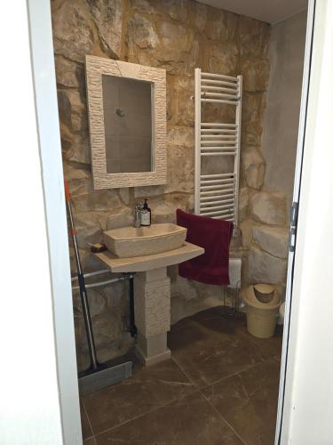 a stone bathroom with a sink and a mirror at Eagles Nest Guesthouse- Garden Lily House in Batroûn