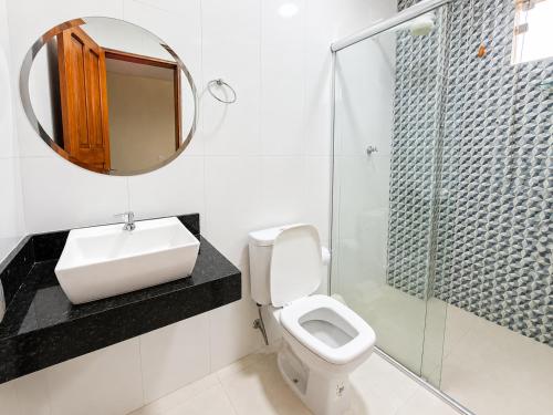 ein Badezimmer mit Waschbecken, Toilette und Spiegel in der Unterkunft Sumaúma Hotel in Tefé