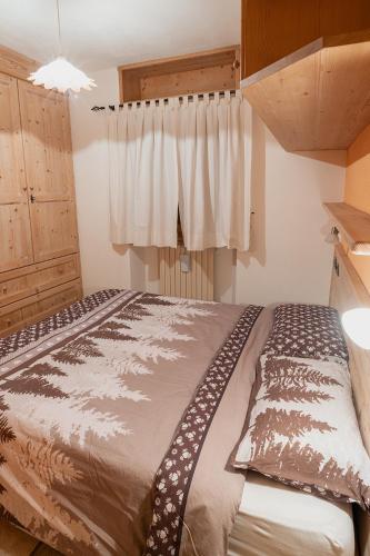 a bedroom with a large bed with a curtain at Appartamento TreZero in Valfurva
