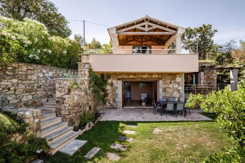 a house with a stone wall and a patio at BeLocations - Aldia Garden Seaview in Puntaldia