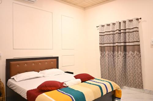 a bedroom with a bed and a curtain at SHANKARDHABA&resort in Guwahati