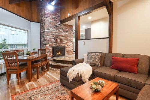 a living room with a couch and a table and a fireplace at Little Haven Cottage in Glacier