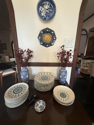 a table with plates and vases on a wall at VILLA ARATOCA in Garça