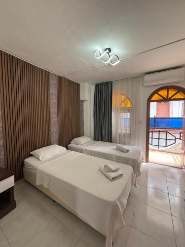 a hotel room with two beds and a window at Sincer Otel in Kuşadası