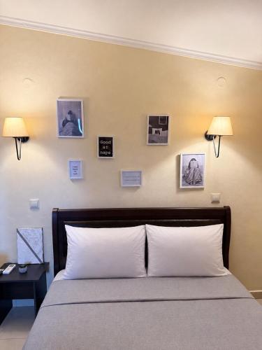 a bedroom with a bed with pictures on the wall at Resort Dimitris in Alexandroupoli
