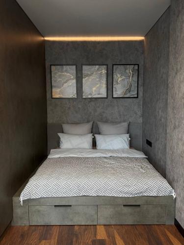 a bedroom with a bed with three pictures above it at Studio Loft in Fontanka