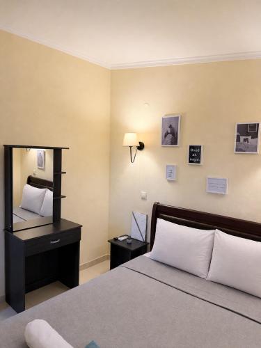 a bedroom with a bed and a desk with a mirror at Resort Dimitris in Alexandroupoli