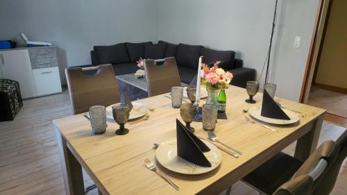a wooden table with plates and napkins on top of it at Ferienwohnungen auf einem rustikalen 3 Seitenhof in Göda