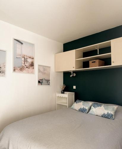 a bedroom with a bed and a green wall at La Perle des Pins LACANAU OCEAN in Lacanau