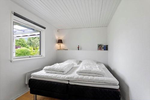 a bed in a white room with a window at LL275-svendborg-Stenklovervej-2 in Svendborg