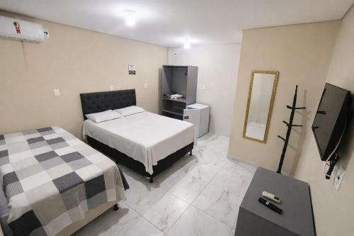 ein Schlafzimmer mit einem Bett und einem Fernseher in der Unterkunft Pousada Paulo's in Caruaru