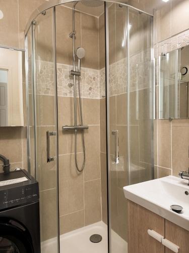 a shower with a glass door in a bathroom at La Perle des Pins LACANAU OCEAN in Lacanau