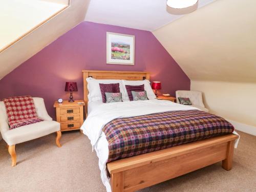 a bedroom with purple walls and a bed and a chair at St Kilda in Ballater