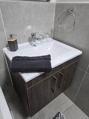 a bathroom with a white sink and a mirror at 77 on Par in Boksburg