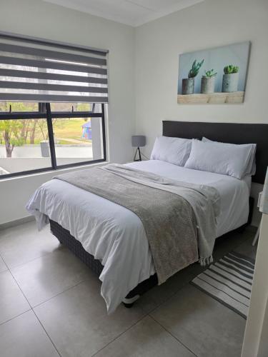 a bedroom with a large bed and a window at 77 on Par in Boksburg