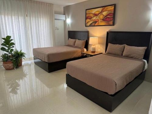 a hotel room with two beds in a room at Hotel Solé Plaza Guadalajara in Guadalajara