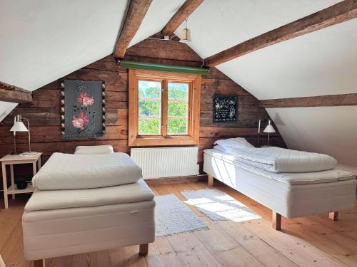 ein Dachgeschosszimmer mit zwei Betten und einem Fenster in der Unterkunft Hus Mida in Högsby