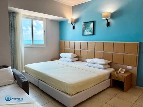 a bedroom with a bed with a blue wall at Negresco Hotel in Marsa Matruh