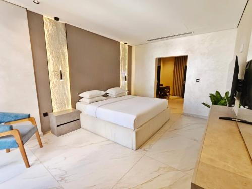 a bedroom with a white bed and a television at 皇冠半岛酒店 - TAJ Boutique Hotel in Baghdād