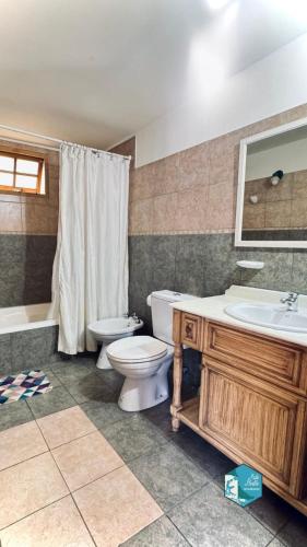 a bathroom with a toilet and a sink and a tub at Isla Bella in Ushuaia