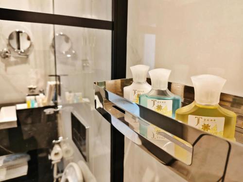 two bottles of perfume on a shelf in a bathroom at 皇冠半岛酒店 - TAJ Boutique Hotel in Baghdād