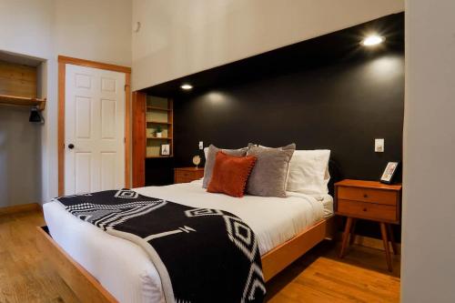 a bedroom with a large bed with a black wall at Colfax Cabin in Glacier