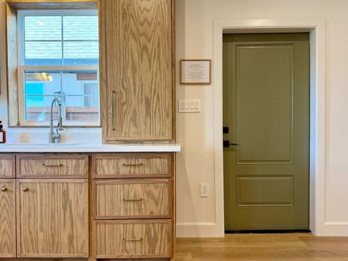 a kitchen with a sink and a green door at Astra B, Designer 3BR, Arcade, Heated Pool in Port Isabel