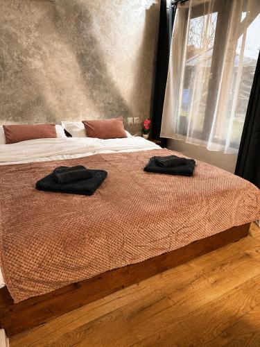two black towels on a bed in a bedroom at MR Tiny House - Private Parking in Roşu