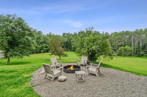 a group of chairs and a fire pit in a yard at Log Cabin Fireplace Upper Valley - Wooded Chalet in Hartland