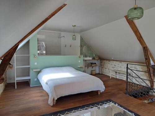 a bedroom with a white bed in a attic at Instant Lot Maison pierre insolite Piscine Nature in Strenquels