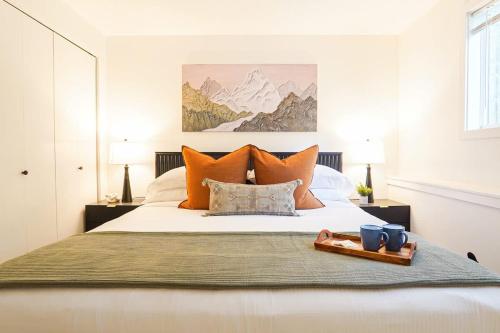 a bed with orange pillows and a tray on it at Twin Lakes Retreat in Glacier