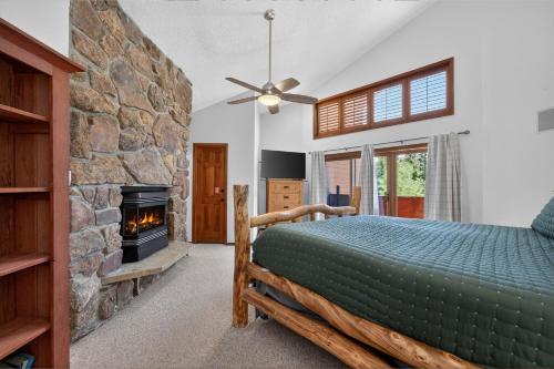 a bedroom with a bed and a stone fireplace at Winter Park Place #18 in Winter Park