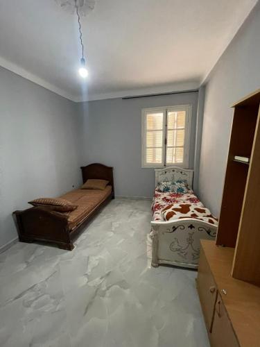 a bedroom with two beds and a window at Front de mer salamndre in Mostaganem