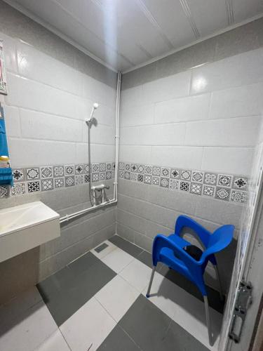 a blue chair in a bathroom with a sink at Front de mer salamndre in Mostaganem