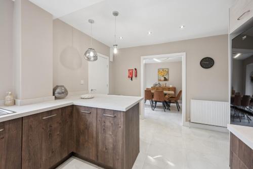 a kitchen with wooden cabinets and a dining room at Spacious Modern home in the heart of Whitefield - Private Driveway Parking in Whitefield