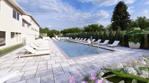 a swimming pool with lounge chairs next to a building at Pell Hotel JdV by Hyatt in Middletown