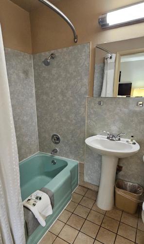 a bathroom with a sink and a bath tub next to a sink at Monroe Motel Near Seattle Everett WA in Monroe