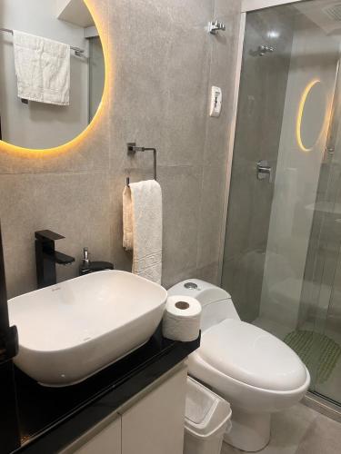 a bathroom with a white sink and a toilet at Garzonier vacacional in Sucre