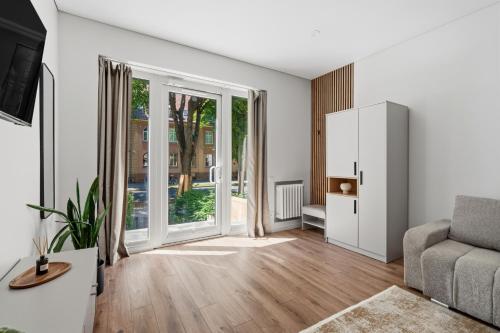 an empty living room with a couch and a large window at Spacious Studio Near Station Klaipėda in Klaipėda