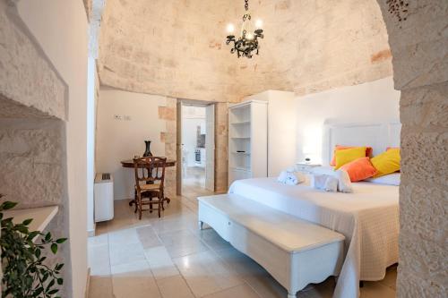 a bedroom with a large bed and a chandelier at Masseria Carperi in Cisternino