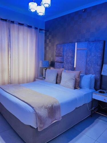 a bedroom with a large white bed with blue lighting at CLASSY and COZY 3 in Fourways