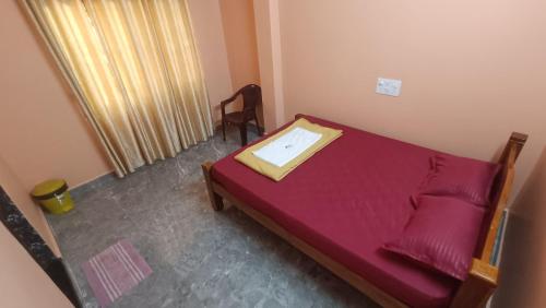 a small bedroom with a red bed in a room at Heera BEACH WAVE STAY in Gokarn