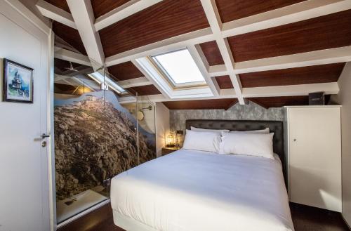 a bedroom with a large bed and a skylight at Hotel O Semaforo in Finisterre