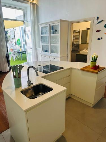 a kitchen with white counters and a sink at ToledoStation B&B in Naples