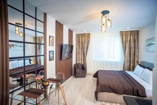 a bedroom with a bed and a desk and a window at Ariana Deluxe Suites in Bucharest