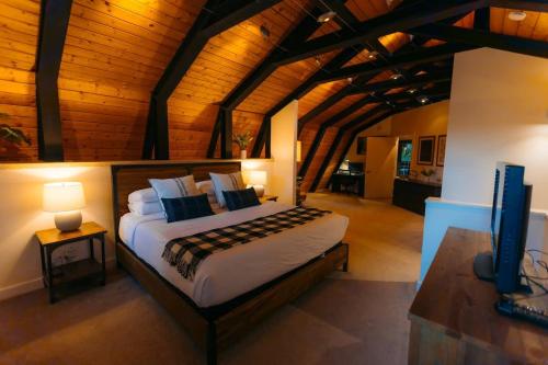 a bedroom with a bed in a room with wooden ceilings at Alpine Lodge in Glacier