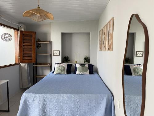 a bedroom with a blue bed and a mirror at Pousada Flor do Sol in Fortaleza